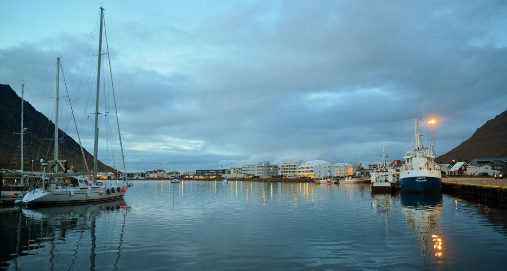 Ísafjörður harbour at blue hour, with waterfront buildings and boats near the town centre where Dokkan Brugghús is located