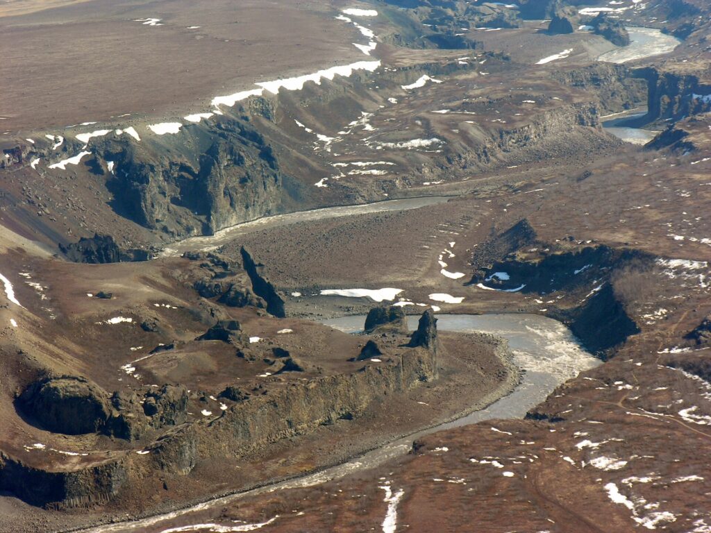 Aerial drone-style view of an Icelandic river winding through open farmland