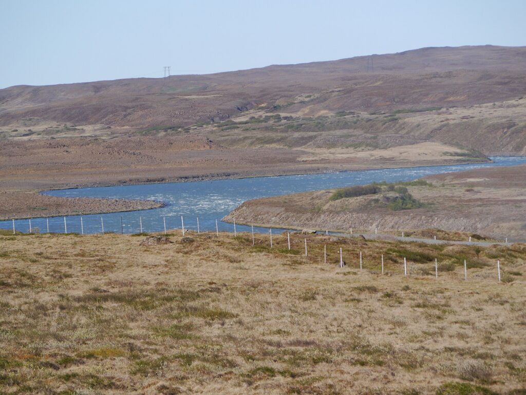 The Hvítá river in Borgarfjörður, West Iceland, meandering through open countryside with river terraces and low hills.