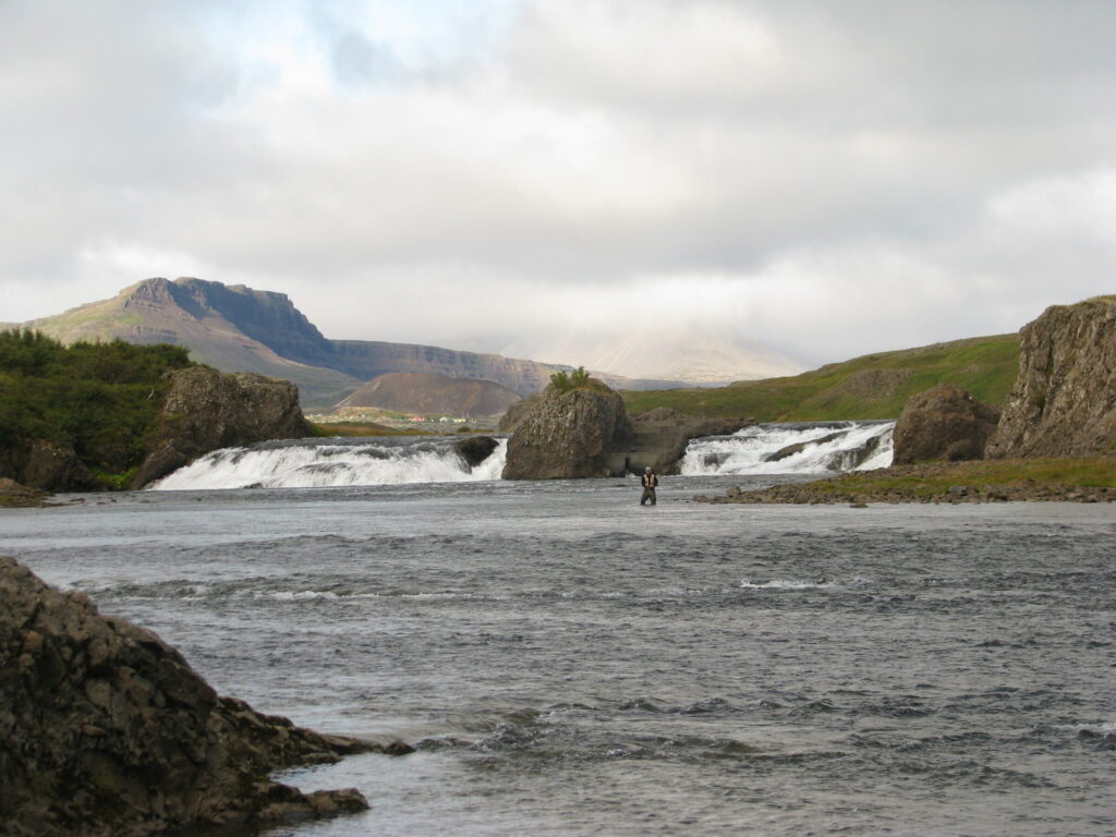 Laxfoss, a low, wide waterfall on the Norðurá river in West Iceland, water cascading white over dark rock ledges.