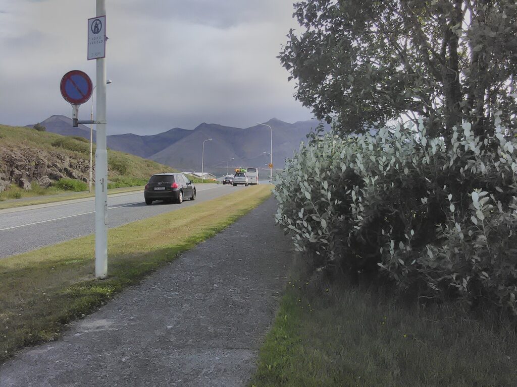 Shoreline walkways in Borgarnes, West Iceland, running along the water with the fjord and hills beyond.
