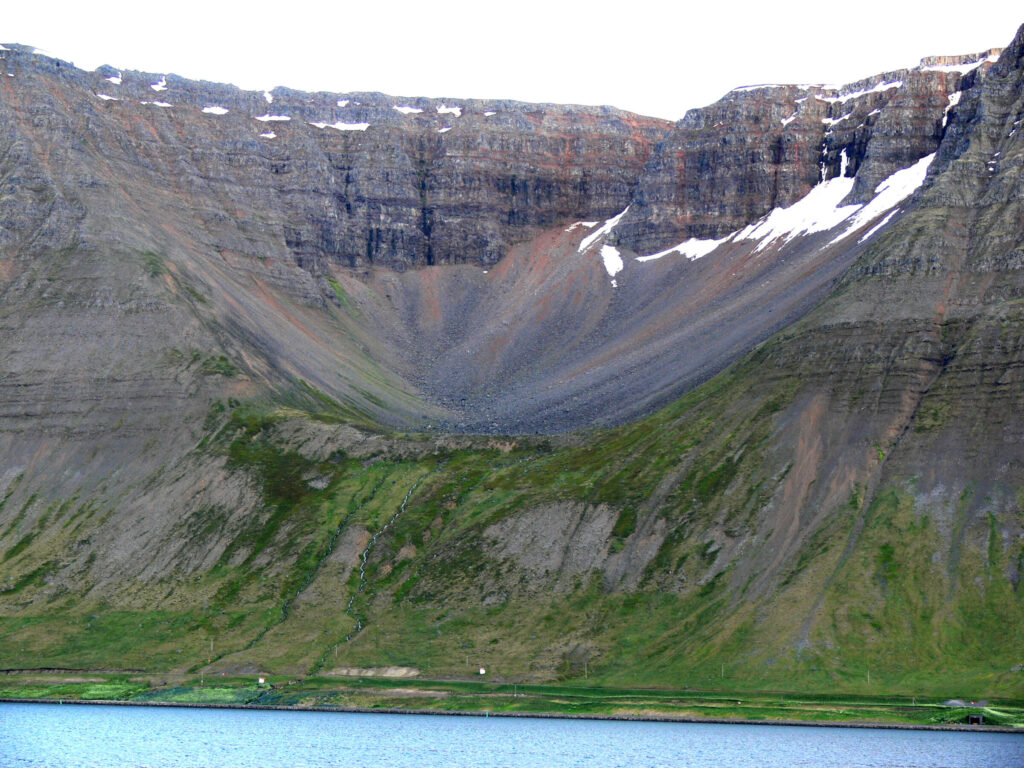 Glacially-eroded cliffs of Eyrarfjall mountain rising above Skutulsfjörður fjord near Ísafjörður in Iceland's Westfjords.