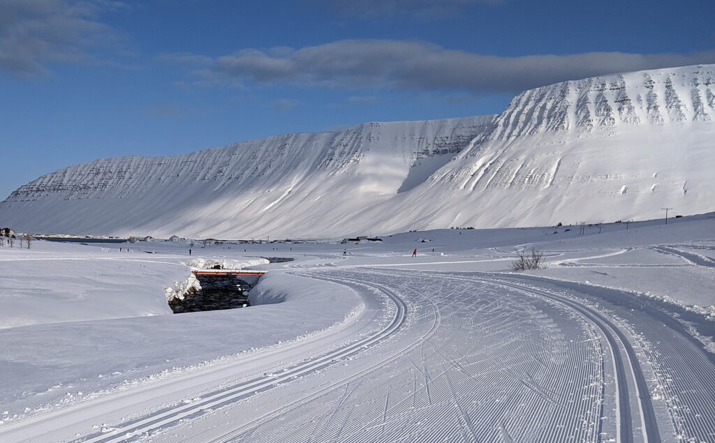 Groomed cross-country ski track in Tungudalur valley near Ísafjörður, Iceland, with snow-covered slopes in the background