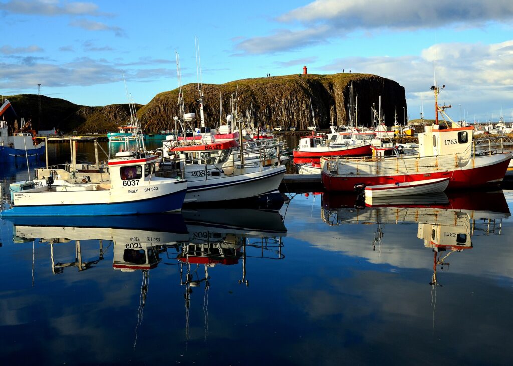 Boats and buildings along the harbour in Stykkishólmur, Iceland, with Breiðafjörður bay in the background