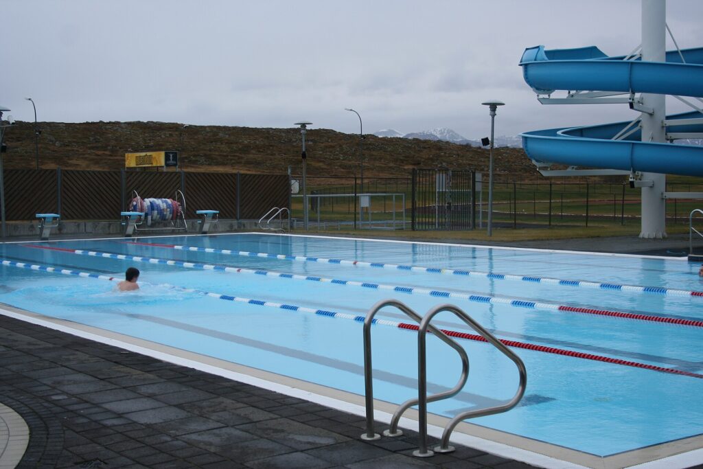 The water slide and outdoor pool area at Sundlaug Stykkishólms, the town swimming pool in Stykkishólmur, Iceland