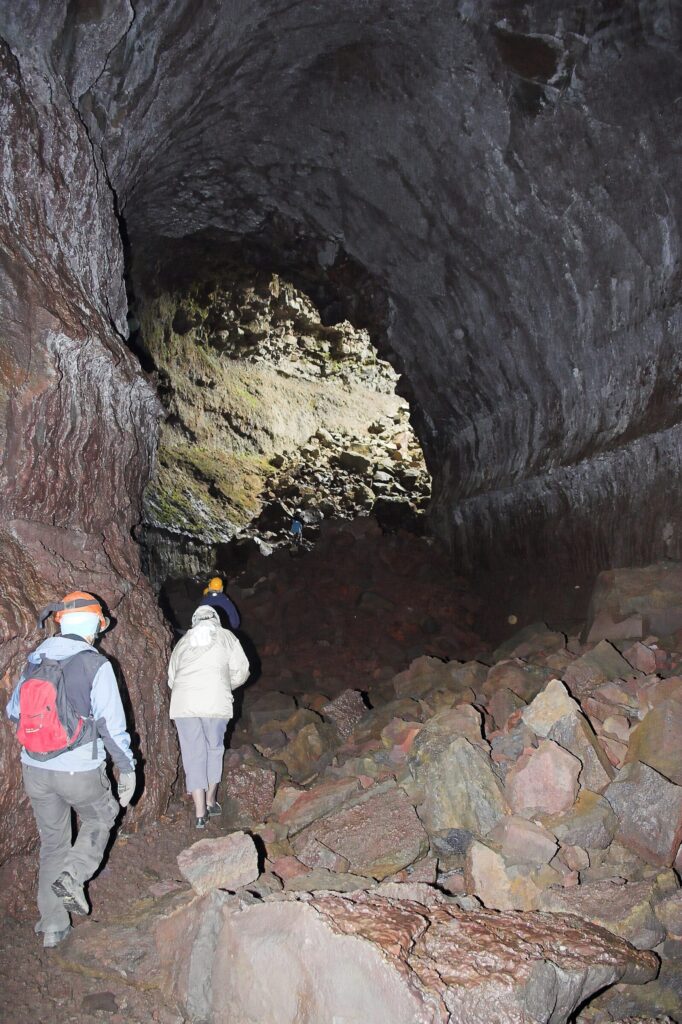 The interior of Víðgelmir lava cave in West Iceland, showing the rock walls and floor of the lava tube lit from within.