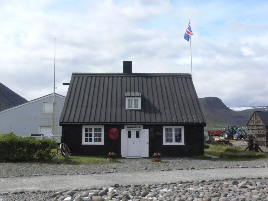 Row of dark 18th-century timber warehouse buildings at Neðstikaupstaður in Ísafjörður's old harbour
